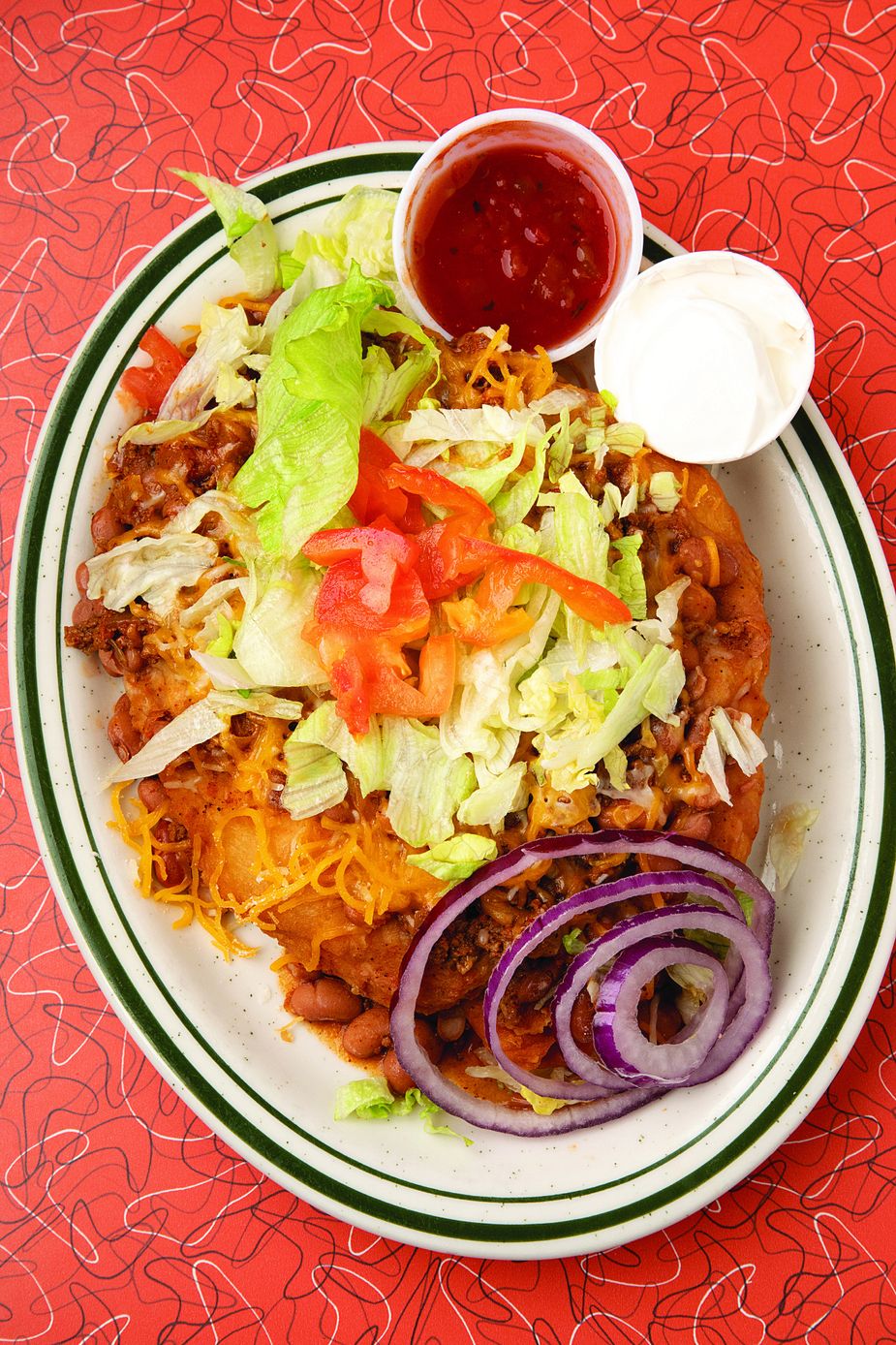 Hot fry bread topped with chili, beans, cheese, lettuce, tomato, and onions makes the Tahlequah Taco a local favorite, but this Del Rancho special is only available at the Tahlequah location.