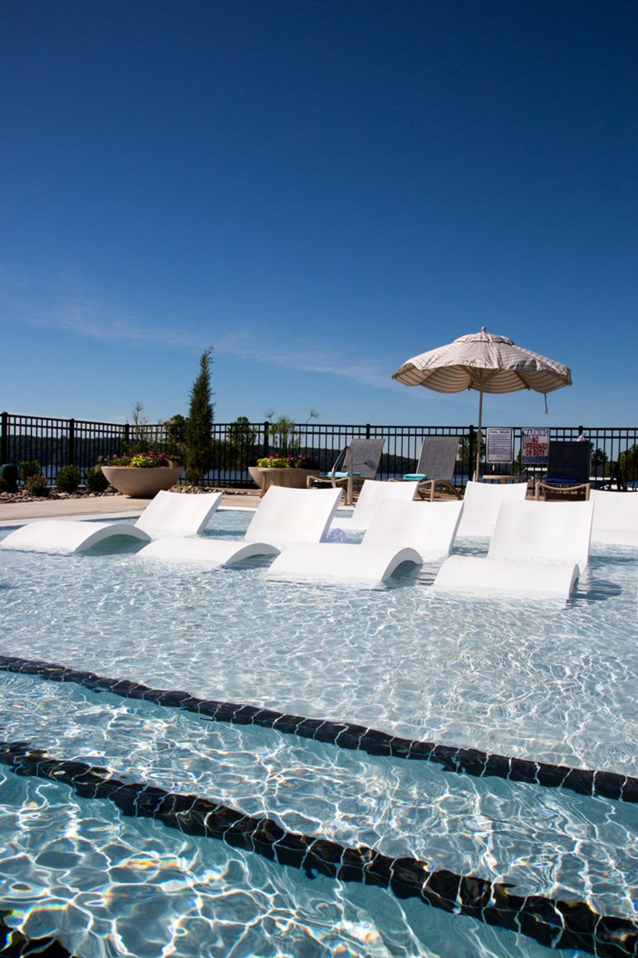 Lounge chairs in the pool's shallow end keep sunbathers cool.