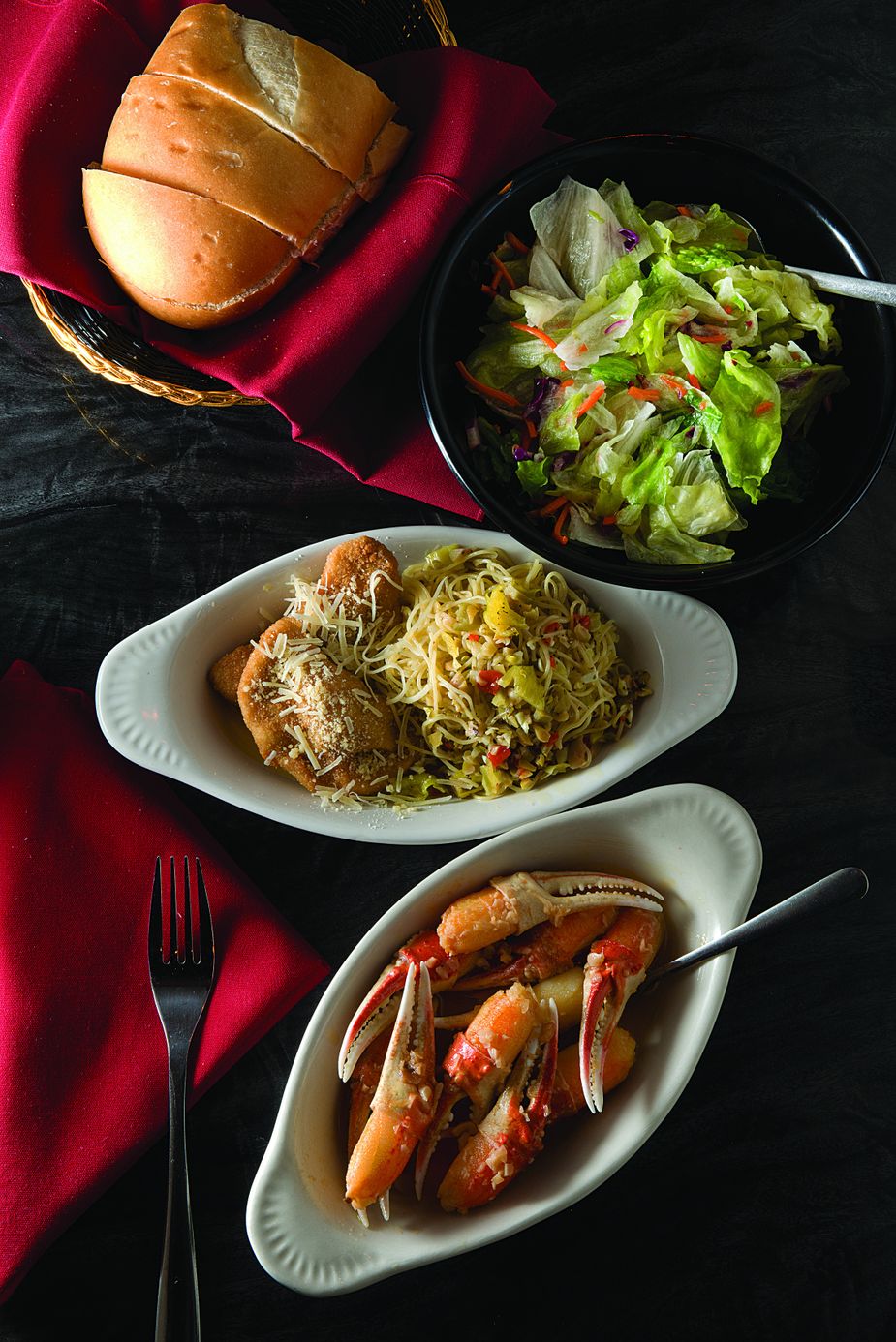 The Toscani Dinner at Isle of Capri in Krebs includes bread, salad, crab claws, fried ravioli, and white spaghetti. Photo by John Jernigan.